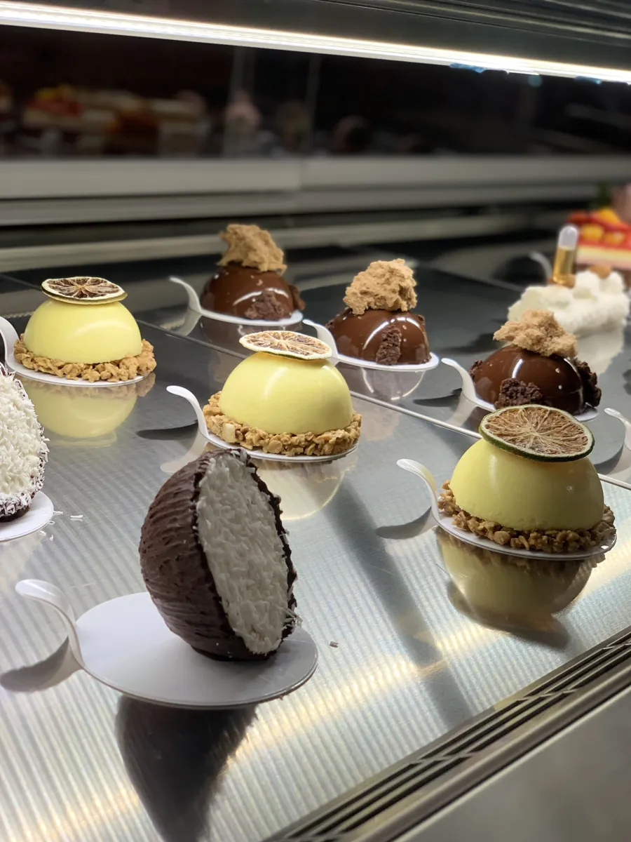 Chocolate coconut, mango and chocolate domed desserts in Mistura’s pastry case