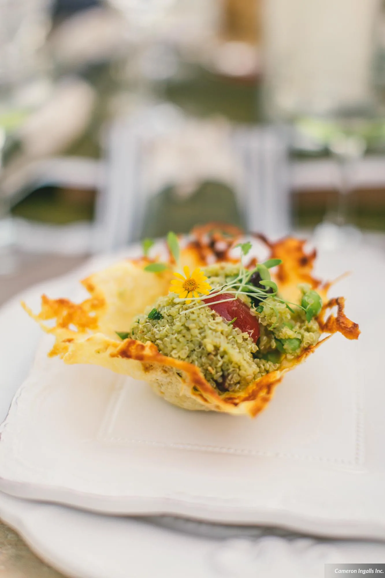 A crisp quinoa tuile topped with edible flowers