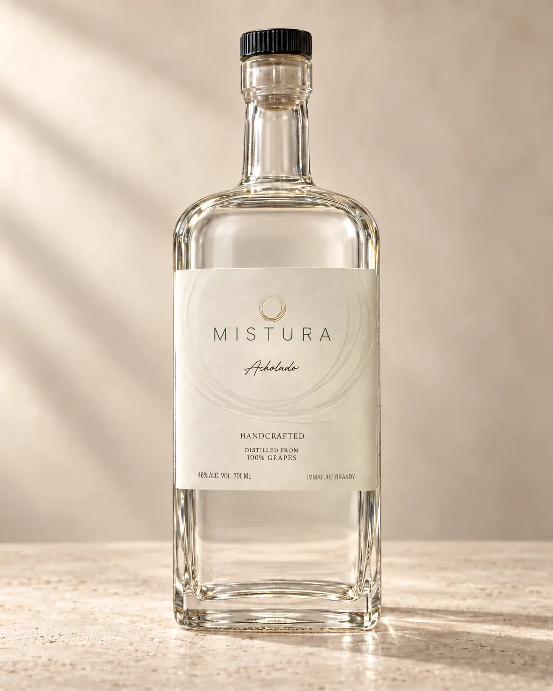 A bottle of Mistura Acholado immature brandy on a stone counter in soft sunlight