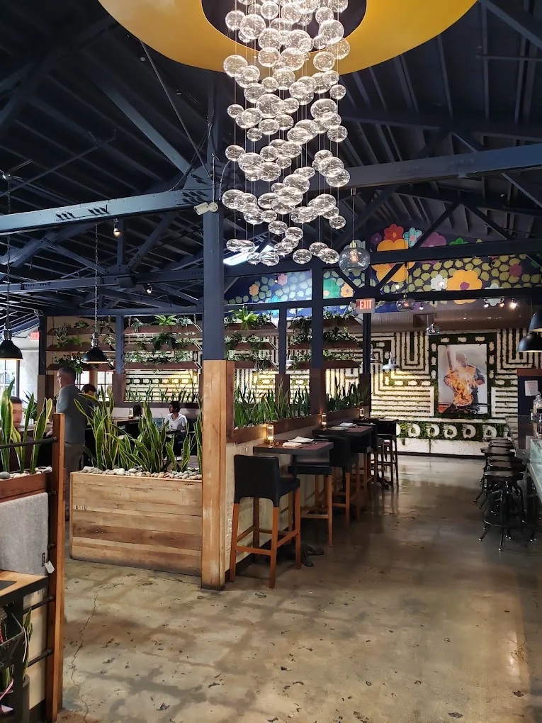 Mistura’s dining room and bar under a chandelier of glass globes